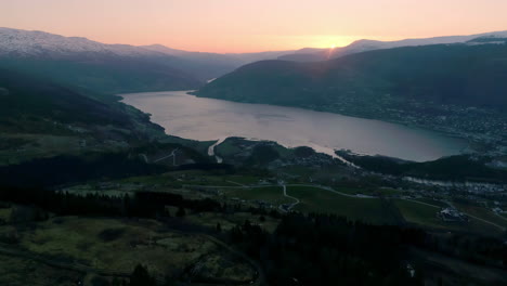 Aerial-wide-shot-of-beautiful-landscape-with-Fjord-mountains-And-golden-sunset-in-background