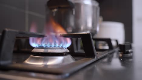 Man-hand-starting-the-gas-burner-for-cooking-dinner,-blue-flames