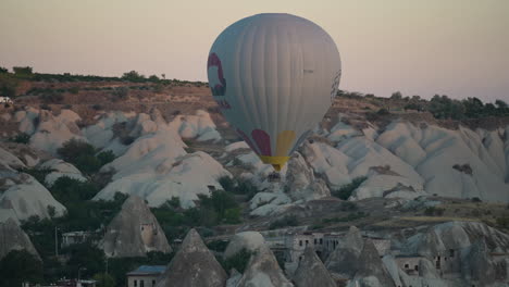 Globo-Aerostático-Al-Amanecer-Volando-Bajo-Sobre-El-Paisaje-De-Capadocia,-Turquía
