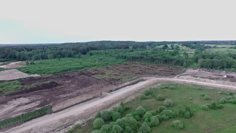 Aerial-shot-of-deforestation-in-a-lush-green-area-on-a-grey-day