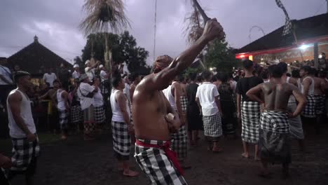 Balinese-man-celebrate-Galungan-Kuningan,-walking-in-the-street-holding-a-big-knife