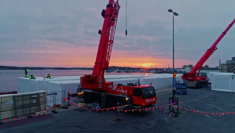 Aerial-view-of-cranes-loading-container-at-port-of-Slottsholmen-in-Sweden-during-sunset