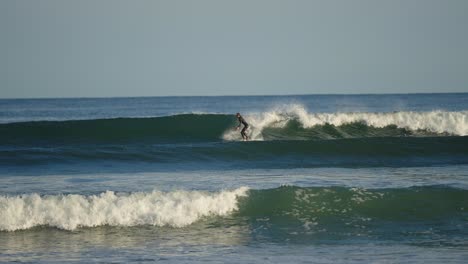 Surfer-Reitet-Eine-Welle-In-Einem-Neoprenanzug-Auf-Einem-Kurzen-Brett