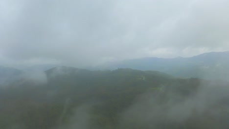 The-drone-shot-captures-the-beauty-of-the-tropical-mountains-as-it-moves-forward-into-the-clouds,-revealing-a-stunning-view-of-the-lush-green-peaks-and-valleys