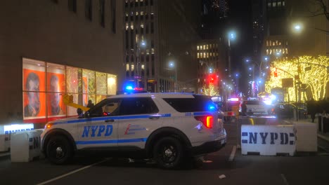 NYPD-Police-Car-Siren-Lights-Flashing-Parked-By-The-Roadside-With-Security-Concrete-Barriers-At-Night-In-New-York-City,-USA
