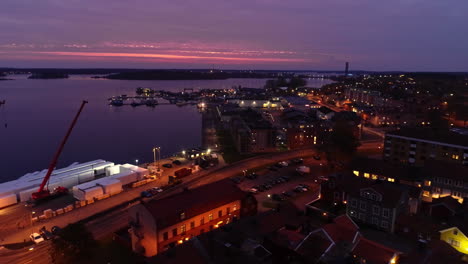 Aerial-trucking-shot-of-cranes-at-port-in-Slottsholmen-City-during-purple-sunset-in-Sweden