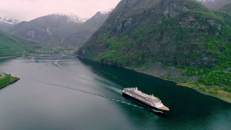 Aerial-view-of-Cruiser-Ship-on-natural-Fjord-of-Norway-between-Mountains-during-cloudy-day