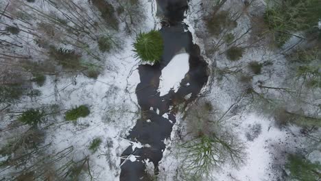Luftaufnahme-Des-Nordischen-Waldes,-Der-Mit-Leichtem-Schnee-Und-Einem-Dunklen-Fluss-Bedeckt-Ist,-Bewölkter-Wintertag,-Niedrige-Wolken,-Entspannende-Aussicht,-Aufsteigende-Drohnenaufnahme-Aus-Der-Vogelperspektive