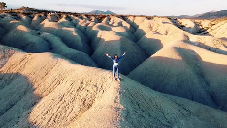 Landscape-of-dunes-desert-drone-point-of-view-of-woman-traveling-through-Mahoya-in-Spain-against-sunset