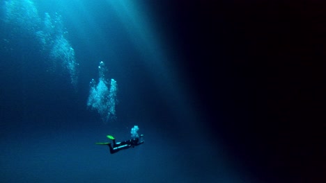 Scuba-diver-in-a-huge-blue-underwater-cave-with-the-sun-hole-on-top