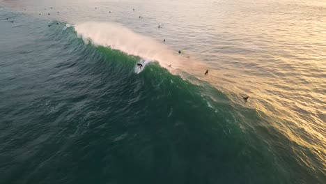drone-view-of-a-surfer-dropping-in-on-a-big-wave-in-la-Jolla,-blacks-beach