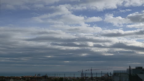 Las-Nubes-Se-Mueven-Rápidamente-A-Través-Del-Cielo-Ciudad-Ensombrecida-Por-El-Mar-Creando-Una-Atmósfera-Brumosa-Y-Aburrida-En-La-Distancia-Sobre-La-Bulliciosa-Metrópolis-En-Un-Clima-Sombrío