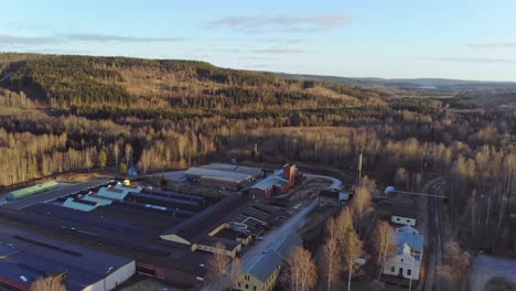 Drone-rising-over-industry-building-in-Bongbro,-Sweden