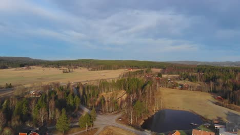 Drone-shot-of-farm,-gravel-pit-and-pond