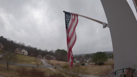Overcast-gloomy-American-suburbs-USA-flag-blowing-in-wind-timelapse