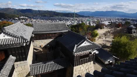 View-over-the-walls-and-roofs-of-the-old-samrai-castle-in-Matsuyama,-Ehime-,-Shikoku,-Japan