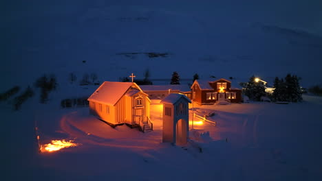 Orange-lit-church-in-a-thick-pack-of-snow-in-Iceland-at-night