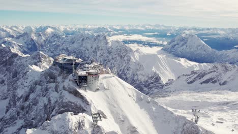 Rotierende-Antenne-Des-Gipfels-Der-Zugspitze-Ein-Berg-In-Den-Alpen-Mit-Einem-Beeindruckenden-Gebäude-An-Der-Spitze