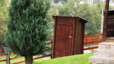 Rustikale-Außentoilette-Aus-Braunem-Holz-Auf-Einem-Hügel