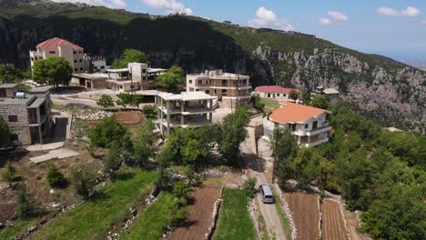 Aerial-View-of-Van-Arriving-in-Village-With-Christian-Church-in-Qadisha-Valley,-Lebanon