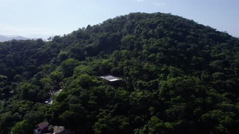 Aerial-view-rising-over-mountainside-rainforest-revealing-seascape-in-Costa-Verde,-sunny-Brazil