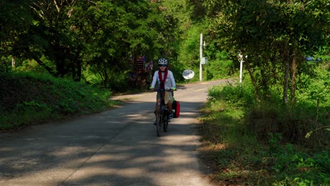 Front-view-of-cyclist-women-in-the-forest-road-of-Pak-Nai-fisherman-village,-Nan-province,-Thailand