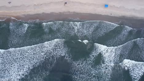 Aerial-view-of-waves-at-the-Barra-Do-Sahy-beach,-in-Brazil---cenital,-drone-shot