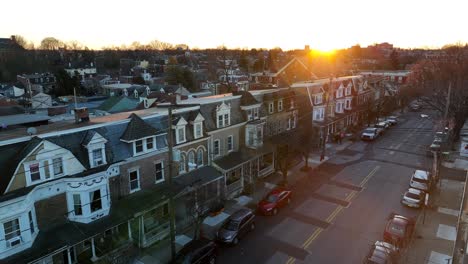 Slow-aerial-of-row-houses-in-urban-city,-Beautiful-sunset-during-winter-scene