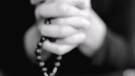 woman-praying-with-hands-together-with-cross-on-black-background-with-people-stock-video