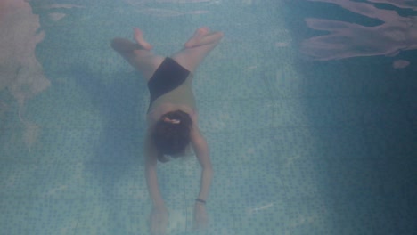 Eine-Junge-Frau-Schwimmt-In-Einem-Schwimmbecken-Unter-Wasser-Auf-Die-Kamera-Zu