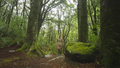 Woman-enjoying-lush-green-outdoor-forest-in-New-Zealand,-Rob-Roy-Hike-Track
