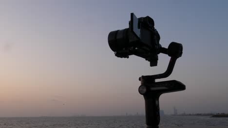 Silhouette-Der-Kamera-Auf-Dem-Kardanischen-Stabilisator,-Der-Den-Sonnenuntergang-über-Dem-Ozean-Filmt