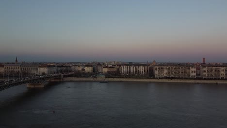 Luftaufnahme-Des-Verkehrs-An-Der-Brücke-über-Der-Donau-Während-Des-Sonnenuntergangs-In-Budapest-Mit-Der-Stadt-Im-Hintergrund