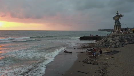 Gajah-Mina-Statue-Am-Strand-Von-Bali,-Während-Freiwillige-Müll-Vom-Strand-Säubern