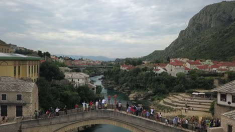 High-divers-prepare-to-jump-into-river-from-tall-bridge-in-Bosnia