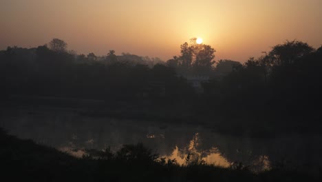 sun-rise-behind-tree-near-the-hot-water-spring-river-fog-on-water-mist-in-air-cold-morning-moving