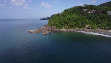 Aerial-view-around-a-rocky-bay-at-Barra-Do-Sahy,-in-sunny-Costa-Verde,-Brazil---circling,-drone-shot