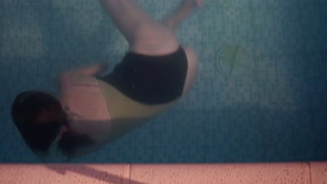 Eine-Junge-Frau-Dreht-Sich-Um-Und-Schwimmt-Unter-Wasser-Von-Der-Kamera-Weg