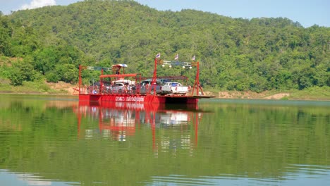 Toma-De-Un-Ferry-Rojo-Navegando-Con-Autos-En-Cubierta-En-El-Pueblo-De-Pescadores-De-Pak-Nai,-Provincia-De-Nan,-Tailandia-En-Un-Día-Soleado