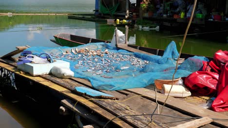 Fishes-kept-over-the-net-in-the-sailing-boat-at-Pak-Nai-fisherman-village,-Nan-province,-Thailand
