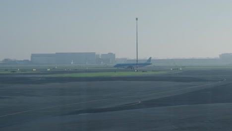 Tracking-shot-of-a-plane-being-taxied-along-the-runway-for-takeoff-at-Rotterdam
