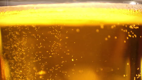Extreme-Close-up-of-craft-Beer-bubbles-floating-to-the-top-of-a-pint-glass-with-foam