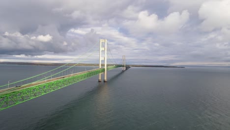 Close-aerial-forwarding-drone-shot-of-the-Mighty-Mac,-Mackinaw,-Bridge,-partly-cloudy-day-above-the-water