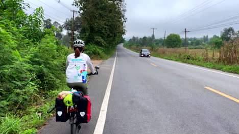 Vista-Trasera-De-Mujeres-Montando-En-Bicicleta-En-La-Carretera-De-La-Provincia-De-Nan,-Tailandia