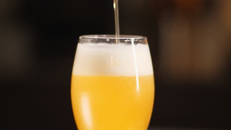 Medium-Craft-Beer,-Das-In-Ein-Goblet-Bierglas-Gegossen-Wird,-Dunkler-Hintergrund