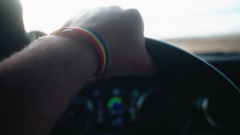 close-up-of-romanian-guy-traveling-on-highway-in-USA-holding-the-steering-wheel-with-an-romanian-moldovian-flag-on-his-hand