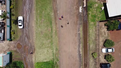 Video-De-Drones-De-Chicos-Caminando-En-Una-Carretera-En-El-Oeste-De-Harare,-Zimbabwe