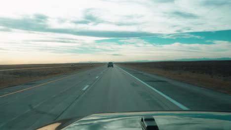 Panoramic-view-from-a-car-driving-on-open-highway-in-flat-landscape,-with-another-vehicle-in-the-distance