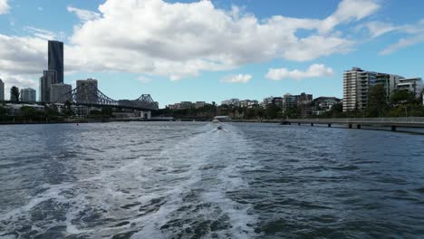 Flying-alongside-the-Brisbane-RiverWalk-towards-the-Story-Bridge-with-boats-in-the-distance