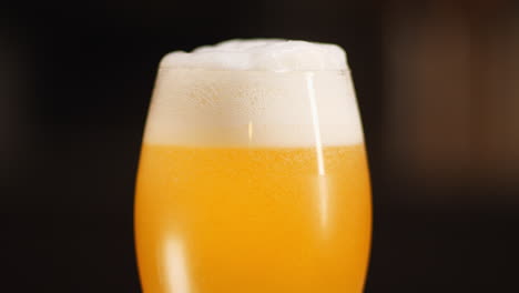 Nahaufnahme-Von-Craft-Beer,-Das-In-Ein-Kelchbierglas-Gegossen-Wird,-Dunkler-Hintergrund